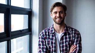 Man smiling with arms folded after cosmetic dentistry in Lakeville, MA