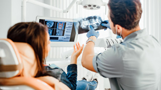 Dentist and patient reviewing X-ray together