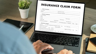 Person filling out insurance claim form on computer