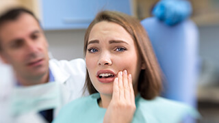 woman in pain holding her cheek