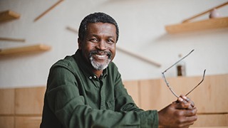 man smiling while holding glasses