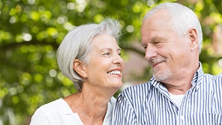 older couple smiling while looking at each other