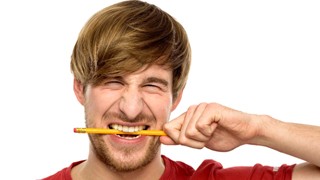 Man with dental implants in Lakeville chewing on a pencil