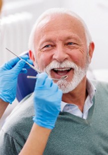 Mature man smiling during dental checkup in New Bedford