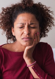 Woman with toothache sitting on couch at home