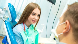 Patient and dental team member discussing cost of smile makeover