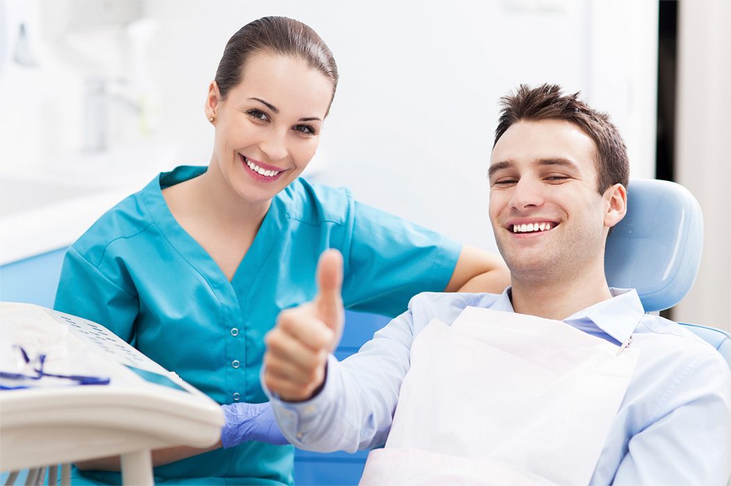 man giving thumbs up in dental chair