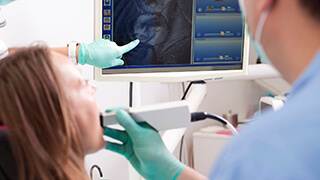 Dentist and patient looking at smile design on computer