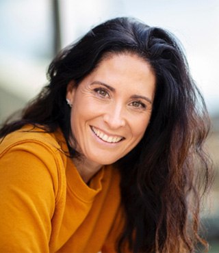 Woman with dark hair smiling with veneers in Lakeville, MA