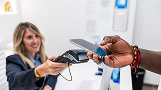 Patient using phone to pay for dental treatment