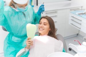 Dental patient looking at her teeth in mirror